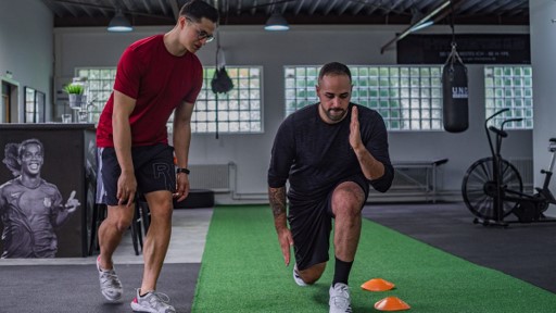 Health coach observing a client's lunge movement pattern during a health and movement assessment