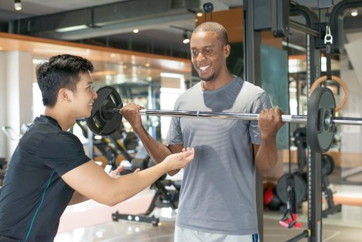 Coach guiding a busy professional through a strength training exercise as part of an executive wellness programme in Dubai